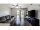 Comfortable living room with dark floors, a gray sofa, and a sliding door at 1100 Lowry Ave # 51, Lakeland, FL 33801