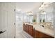 Well-lit bathroom with double vanity, dark wood cabinets, and a large mirror at 1108 Stoney Creek Blvd, Lakeland, FL 33811