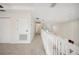 Hallway with neutral carpeting, white railings, and white doors at 1108 Stoney Creek Blvd, Lakeland, FL 33811