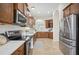 Modern kitchen showcasing stainless steel appliances, tile flooring, quartz countertops, and dark wooden cabinetry at 1108 Stoney Creek Blvd, Lakeland, FL 33811