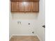 Laundry room with tile floor, utility hookups, and wood cabinets for storage at 1108 Stoney Creek Blvd, Lakeland, FL 33811