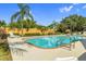 Relaxing community pool featuring lounge chairs, beautiful palm trees, and a meticulously maintained landscape at 1108 Stoney Creek Blvd, Lakeland, FL 33811