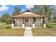 Charming single-story home with a welcoming front porch, complemented by mature landscaping at 1243 Olive St, Lakeland, FL 33815