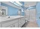 Bright bathroom with a shower, double vanity sink, blue walls, and tile flooring at 1415 Pinewood Ave, Lakeland, FL 33803