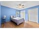 A blue bedroom with a closet and light hard wood floors at 1415 Pinewood Ave, Lakeland, FL 33803