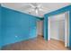 Bedroom with a ceiling fan, light blue walls, wood-look floors, and closet at 1415 Pinewood Ave, Lakeland, FL 33803