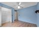 Light blue bedroom with ceiling fan, wood-look floors and closet at 1415 Pinewood Ave, Lakeland, FL 33803