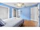 A blue bedroom with a closet and light hard wood floors at 1415 Pinewood Ave, Lakeland, FL 33803