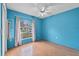 Bedroom with a ceiling fan, light blue walls, wood-look floors, and window at 1415 Pinewood Ave, Lakeland, FL 33803