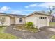 Charming single-story home with an attached two-car garage, landscaped features and concrete walkway at 1415 Pinewood Ave, Lakeland, FL 33803