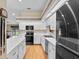 Bright kitchen featuring white cabinets, modern black appliances, and a wood floor at 1415 Pinewood Ave, Lakeland, FL 33803