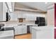 Well-lit kitchen with modern appliances, white cabinetry, and wood-look flooring at 1415 Pinewood Ave, Lakeland, FL 33803