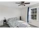 This bedroom features a window with natural light, a ceiling fan, and floral bedding at 14439 Prunningwood Pl, Winter Garden, FL 34787