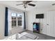 Bright bedroom featuring a ceiling fan, mounted TV, and a large window with curtains at 14439 Prunningwood Pl, Winter Garden, FL 34787