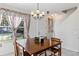 Well-lit dining area with wood table, pendant lighting, large window and a white entry door at 14439 Prunningwood Pl, Winter Garden, FL 34787