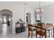 Open-concept dining area with wood table set, chandelier, and archway leading to other rooms at 14439 Prunningwood Pl, Winter Garden, FL 34787