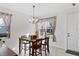 Cozy dining area featuring wood furniture, a chandelier, and natural light streaming through the window at 14439 Prunningwood Pl, Winter Garden, FL 34787