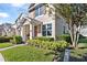 Charming townhome featuring a front porch, decorative shutters, and manicured landscaping at 14439 Prunningwood Pl, Winter Garden, FL 34787