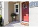 Front porch with a red door, decorative wreath, and potted plant at 14439 Prunningwood Pl, Winter Garden, FL 34787