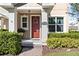 Charming front porch with a red door, decorative wreath, and manicured bushes at 14439 Prunningwood Pl, Winter Garden, FL 34787