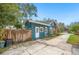 View of the rear of the blue house with white door and trim, and partial fence view at 1618 Robertson St, Lakeland, FL 33803