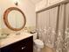 Bathroom features a classic vanity, decorative mirror, toilet, and shower with neutral accents at 1700 6Th Nw St # A36, Winter Haven, FL 33881