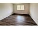 Spacious bedroom with wood-look flooring and ample natural light from a large window at 1700 6Th Nw St # A36, Winter Haven, FL 33881