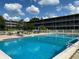 Community pool surrounded by a white fence and lounge seating for residents at 1700 6Th Nw St # A36, Winter Haven, FL 33881