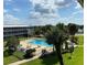 Aerial view of a community pool with palm trees and lawn seating at 1700 6Th Nw St # A36, Winter Haven, FL 33881