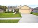 Inviting single-story home featuring a manicured lawn, a two-car garage, and charming landscaping at 1888 Creeks Vista Blvd, Lakeland, FL 33810