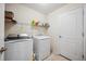 Bright laundry room featuring a washer, dryer, and wire shelving for storage at 1888 Creeks Vista Blvd, Lakeland, FL 33810