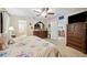 Well-lit main bedroom with plush carpet, ceiling fan, and ensuite bathroom with a soaking tub at 1888 Creeks Vista Blvd, Lakeland, FL 33810