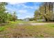 Large backyard with mature shade trees and freshly painted house at 1925 N Combee Rd, Lakeland, FL 33801