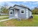 This charming home features a light blue exterior, well-kept lawn, and traditional architectural details at 1925 N Combee Rd, Lakeland, FL 33801