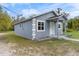 This charming home features a light blue exterior, well-kept lawn, and traditional architectural details at 1925 N Combee Rd, Lakeland, FL 33801