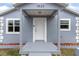 Inviting front entrance with covered porch, showcasing a white door and updated exterior details at 1925 N Combee Rd, Lakeland, FL 33801