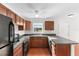 A full kitchen with dark wood cabinets and black appliances offers plenty of storage space at 1925 N Combee Rd, Lakeland, FL 33801