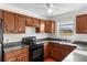 Charming kitchen features wood cabinets, black appliances, laminate countertops, and a double-basin stainless steel sink at 1925 N Combee Rd, Lakeland, FL 33801