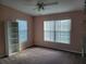 Well-lit bedroom features a large window, carpeting, a ceiling fan, and a built-in shelving unit at 2051 Winterset Dr, Lakeland, FL 33813