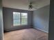 Bedroom featuring a large window with views of the lush greenery, carpet flooring, and neutral walls at 2051 Winterset Dr, Lakeland, FL 33813