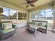 Screened-in lanai with wicker furniture, ceiling fan, and views of the fenced backyard at 2170 Country Manor St, Bartow, FL 33830