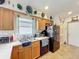 Well-lit kitchen featuring wood cabinets, stainless steel sink, black appliances, and tile flooring at 2206 Silver Lakes N Dr, Lakeland, FL 33810