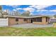 A view of the backyard patio featuring a brick house, a privacy fence, and manicured landscaping at 2330 Peterson Rd, Lakeland, FL 33812