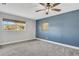 Spacious bedroom with neutral carpet, blue accent wall, and natural light from the window at 2465 Thornhill Rd, Auburndale, FL 33823