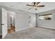 Bedroom with plush carpeting, view to bathroom, and natural light from the window at 2465 Thornhill Rd, Auburndale, FL 33823