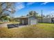 Exterior of detached gray garage with attached awning and yard at 2465 Thornhill Rd, Auburndale, FL 33823