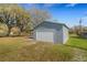 Exterior of detached gray garage with yard and trees at 2465 Thornhill Rd, Auburndale, FL 33823