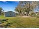 Exterior of detached gray garage with attached awning and yard at 2465 Thornhill Rd, Auburndale, FL 33823