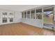 Enclosed sunroom featuring tiled floor, white brick walls, and screened windows at 2465 Thornhill Rd, Auburndale, FL 33823