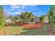 Expansive backyard featuring a screened pool, palm trees, and well-manicured landscaping for ultimate outdoor enjoyment at 2726 Greyhawk Estates Ln, Lakeland, FL 33812